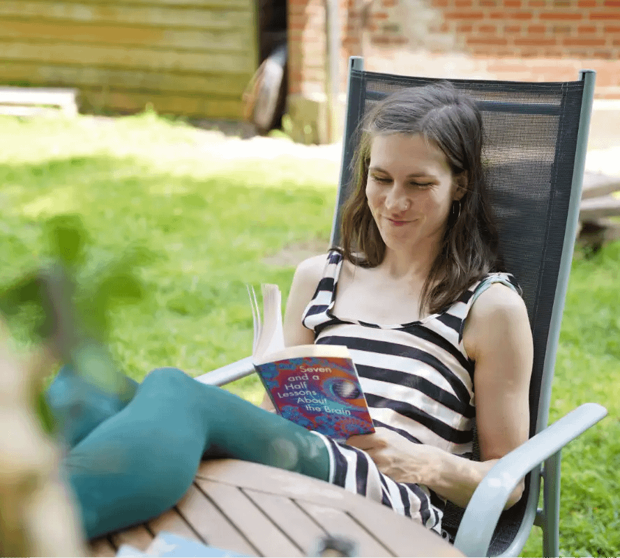 Person reading a book in the garden