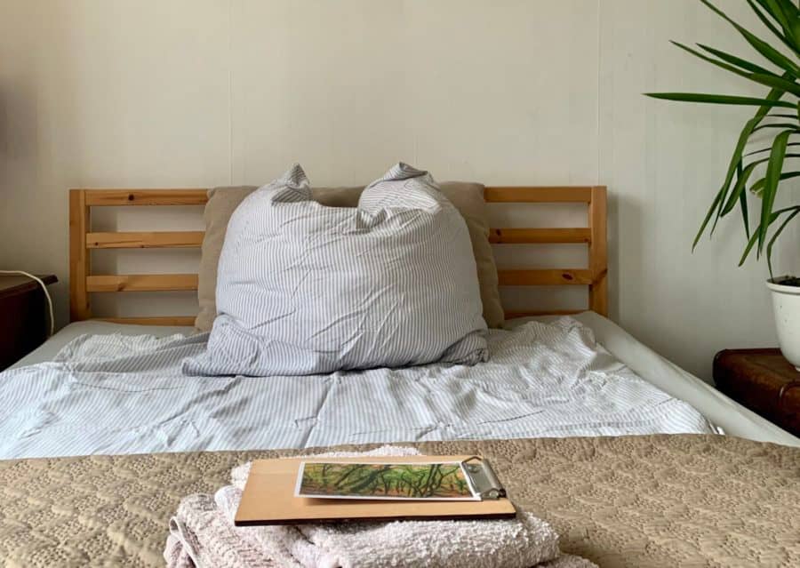 Ein frisch gemachtes Bett mit Holzgestell